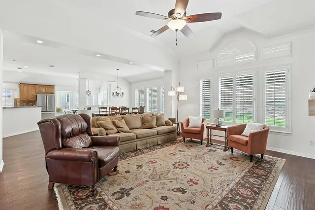 a living room with furniture wooden floor and a large window