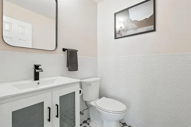a bathroom with a toilet sink and mirror