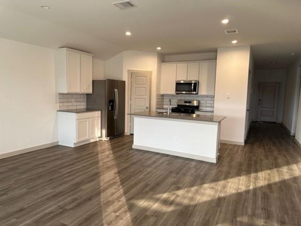 7826 Sleek Flock Lane Rosharon, TX 77583 - Photo 4 of 16 a kitchen with stainless steel appliances a refrigerator and a stove top oven