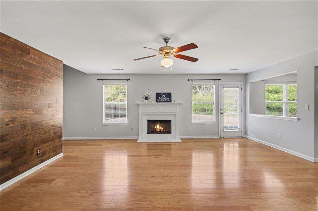 4350 Defoors Farm Trail Powder Springs, GA 30127 - Photo 13 of 35 an empty room with windows fireplace and a kitchen view