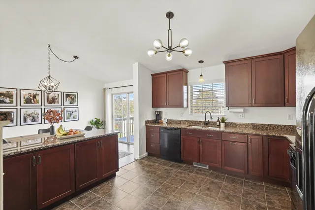 a kitchen with granite countertop stainless steel appliances a sink stove and cabinets
