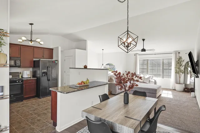 a kitchen with refrigerator cabinets dining table and chairs
