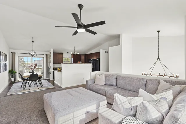 a living room with furniture and a view of kitchen