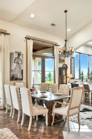 a dining room with furniture a chandelier and wooden floor
