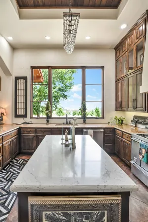 a large kitchen with kitchen island a large window in it