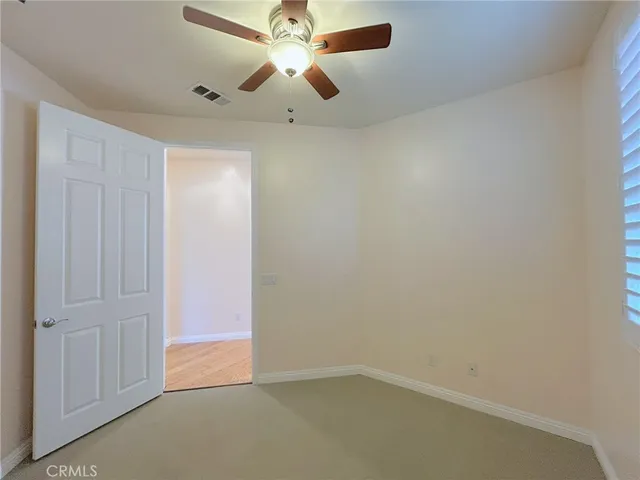 an empty room with a ceiling fan and a window