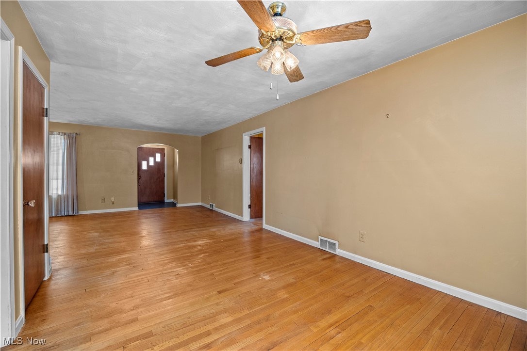 25950 Bagley Road Olmsted Falls, OH 44138 - Photo 4 of 32 Unfurnished room with light wood-type flooring, arched walkways, and ceiling fan