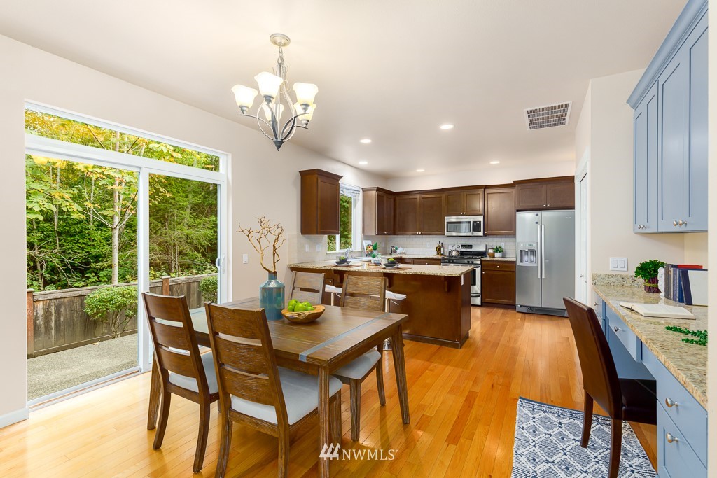 22511 38th Avenue Southeast Bothell, WA 98021 - Photo 8 of 29 a open dining room with stainless steel appliances kitchen island granite countertop a dining table chairs and granite counter tops