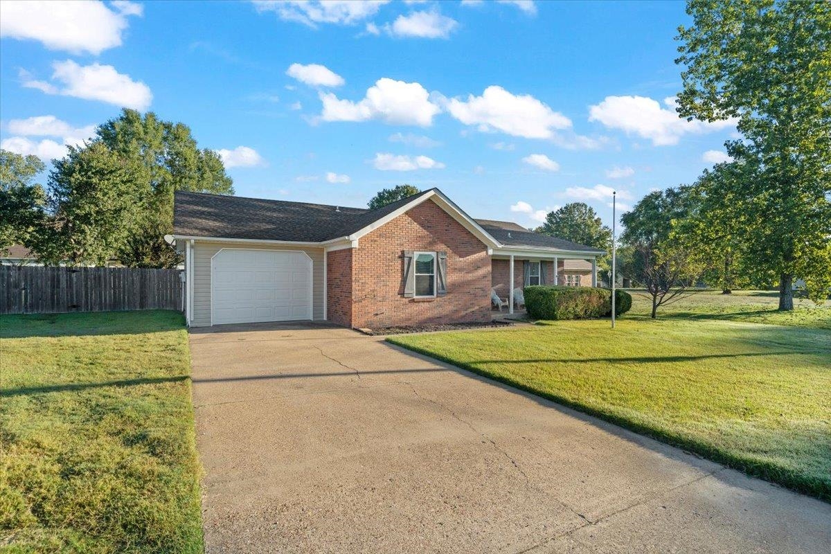 9496 Holly Grove Road Brighton, TN 38011 - Photo 2 of 29 Single story home featuring concrete driveway, brick siding, an attached garage, and covered porch