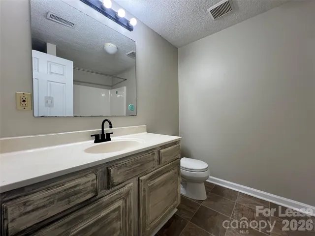 a bathroom with a sink a toilet and mirror