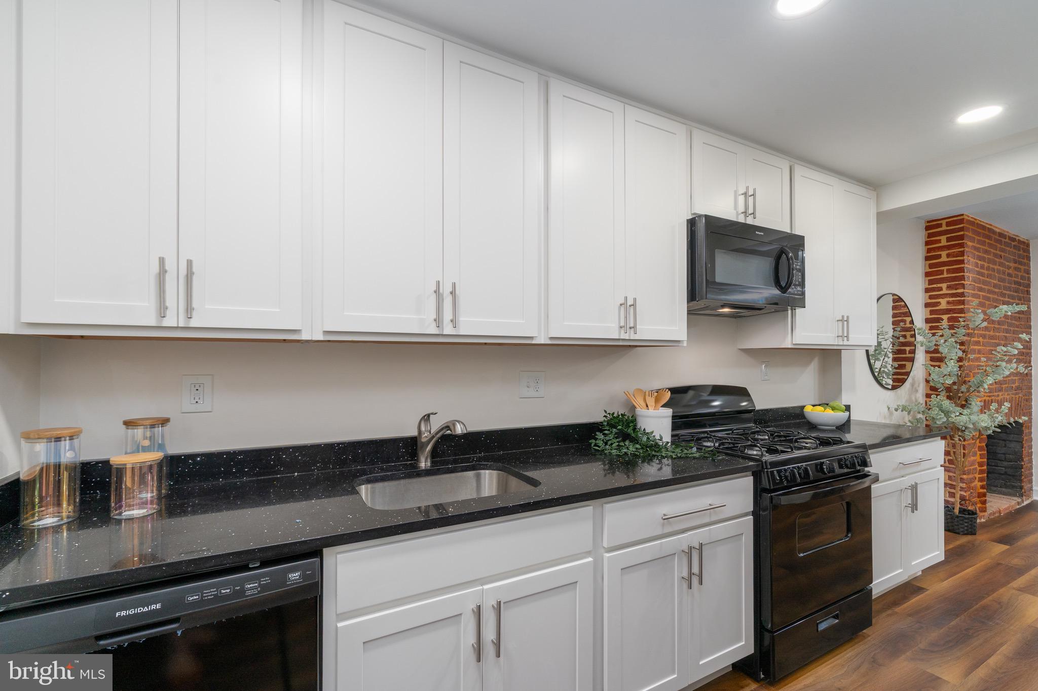 123 East Cross Street Baltimore, MD 21230 - Photo 10 of 33 a kitchen with granite countertop white cabinets and stainless steel appliances