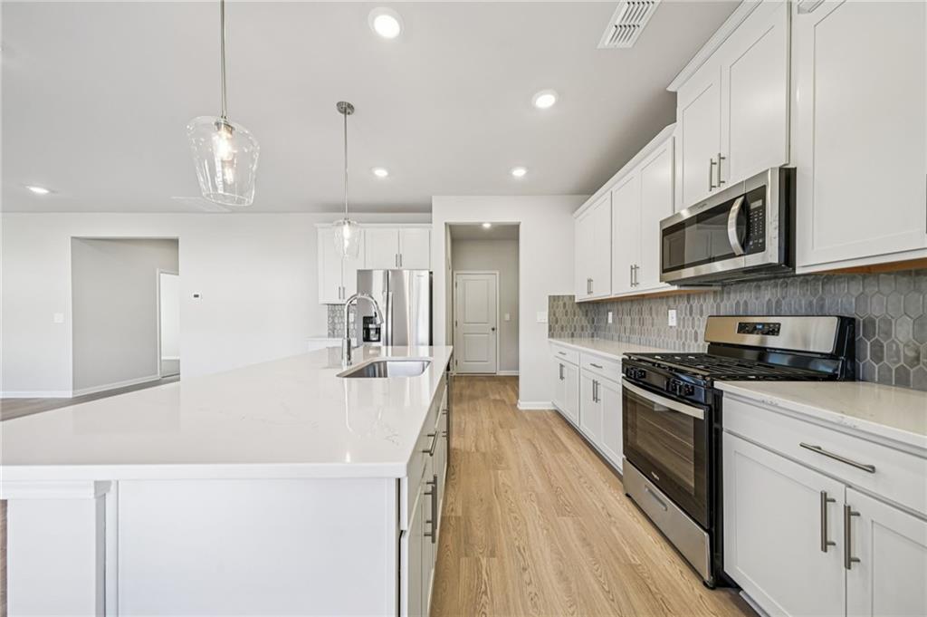 1428 High Fls Lane Grayson, GA 30017 - Photo 12 of 39 a large kitchen with stainless steel appliances granite countertop a stove a sink a refrigerator and a microwave