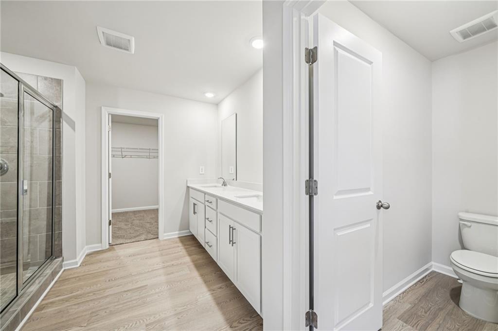1428 High Fls Lane Grayson, GA 30017 - Photo 24 of 39 a bathroom with a double vanity sink toilet and shower