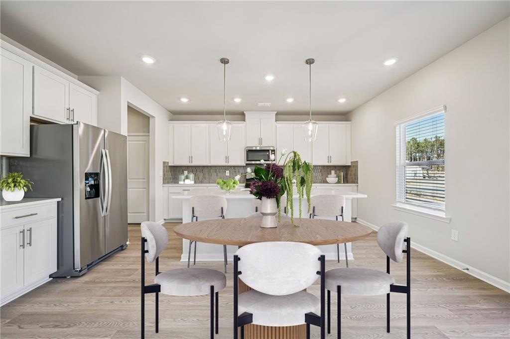1428 High Fls Lane Grayson, GA 30017 - Photo 10 of 39 a kitchen with granite countertop a refrigerator and microwave dining table and wooden floor