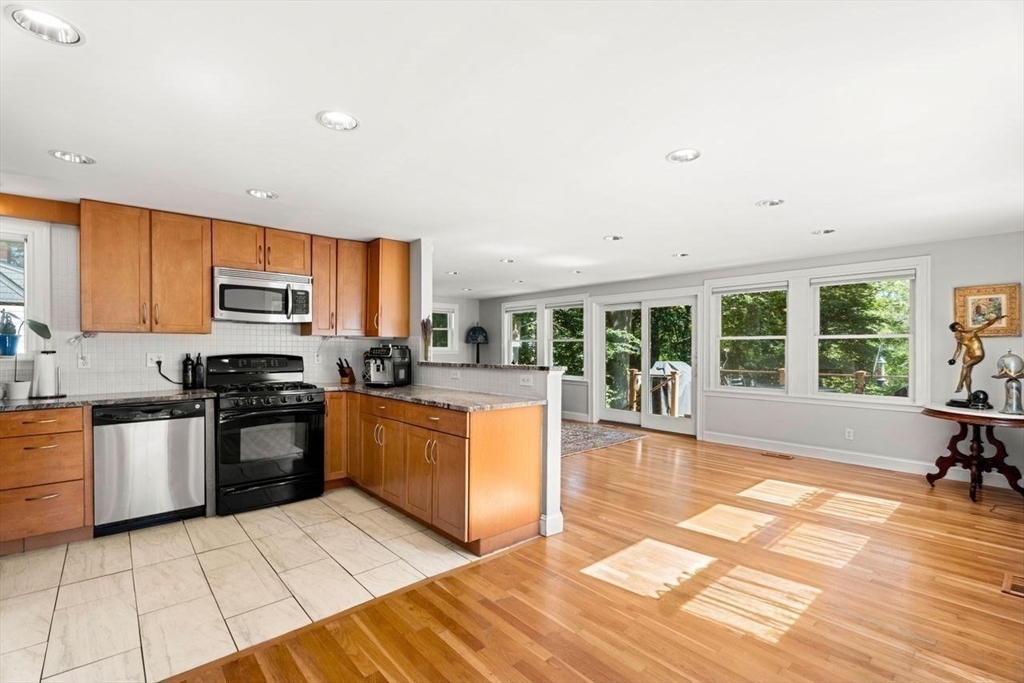 139 Jersey Street Marblehead, MA 01945 - Photo 23 of 42 a large kitchen with stainless steel appliances granite countertop a stove top oven a sink dishwasher a dining table and chairs with wooden floor