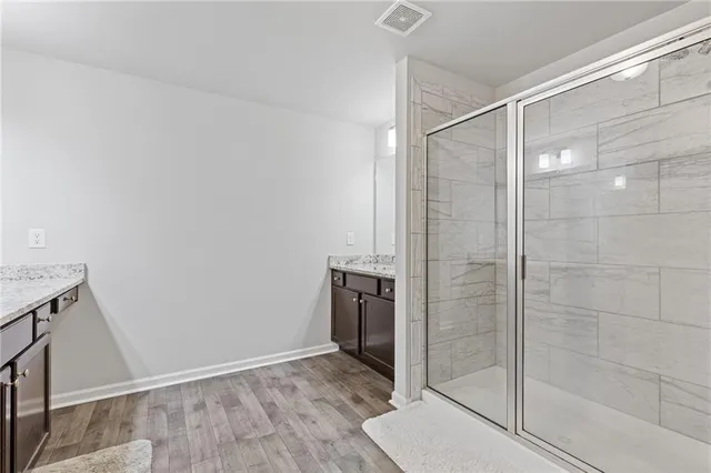 a bathroom with a granite countertop sink a toilet and shower