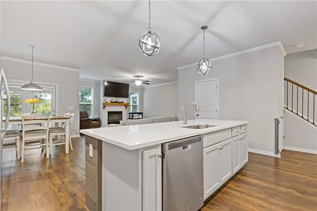 a kitchen with kitchen island granite countertop a sink cabinets and stainless steel appliances