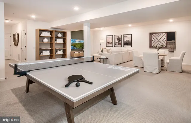 a living room with pool table and windows
