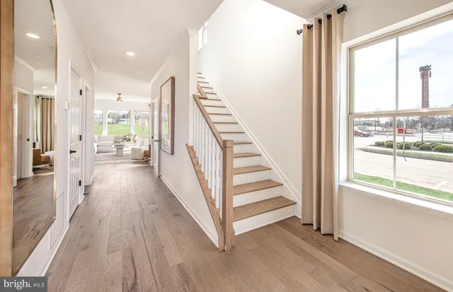 a view of a hallway with wooden floor and staircase