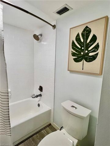 a bathroom with a toilet and a shower curtain