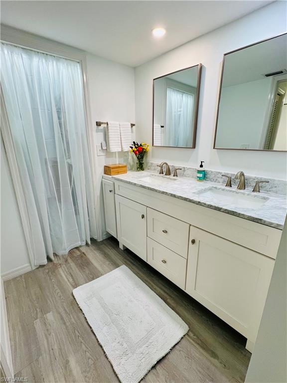 75 St Andrews Boulevard, Unit B203 Naples, FL 34113 - Photo 20 of 38 a bathroom with a double vanity sink and mirror
