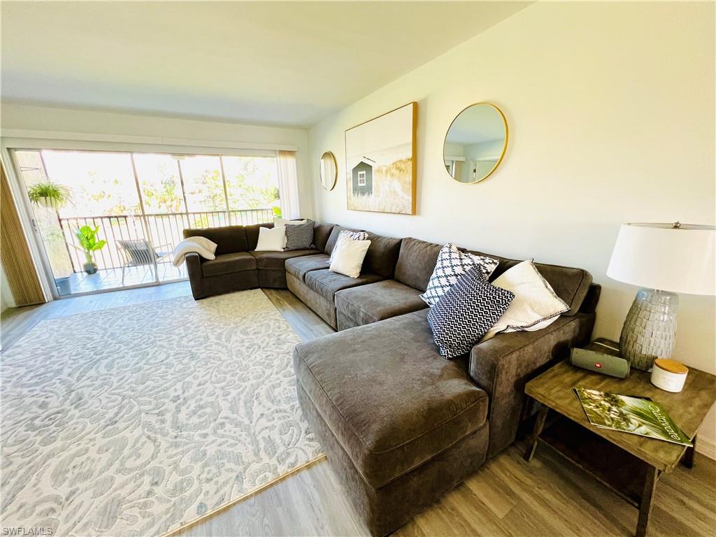 75 St Andrews Boulevard, Unit B203 Naples, FL 34113 - Photo 2 of 38 a living room with furniture and a large window