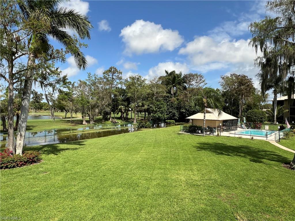 75 St Andrews Boulevard, Unit B203 Naples, FL 34113 - Photo 3 of 38 a swimming pool is sitting in the grass near a house