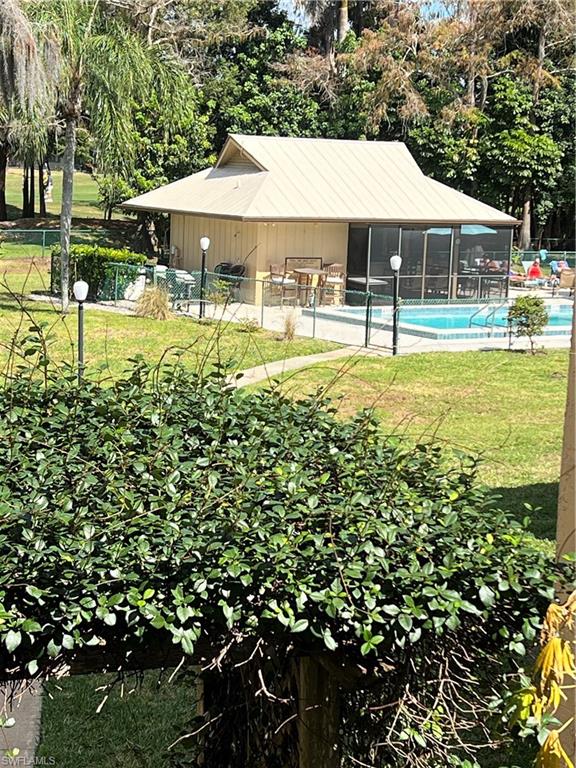 75 St Andrews Boulevard, Unit B203 Naples, FL 34113 - Photo 36 of 38 a swimming pool with outdoor seating and yard