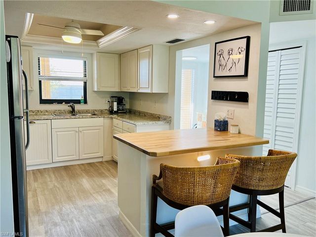 a kitchen with a table chairs sink and cabinets