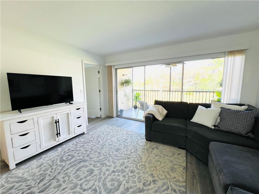 75 St Andrews Boulevard, Unit B203 Naples, FL 34113 - Photo 10 of 38 a living room with furniture and a flat screen tv