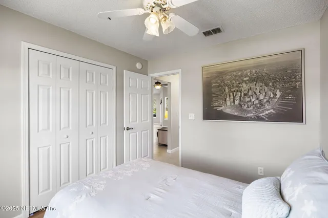 a bedroom with a large bed and a chandelier