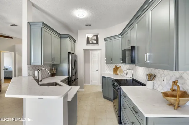 a kitchen with stainless steel appliances kitchen island granite countertop a sink and refrigerator