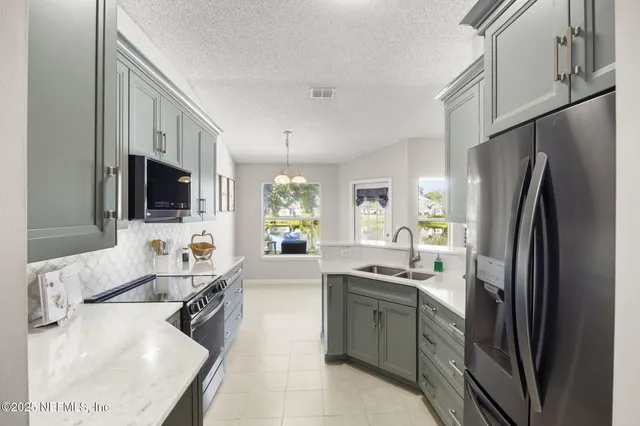 a kitchen with stainless steel appliances a refrigerator sink and white cabinets
