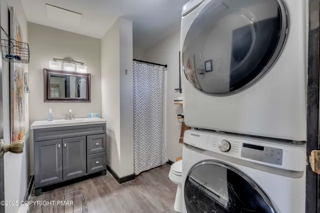 a bathroom with a sink a mirror and wooden floor