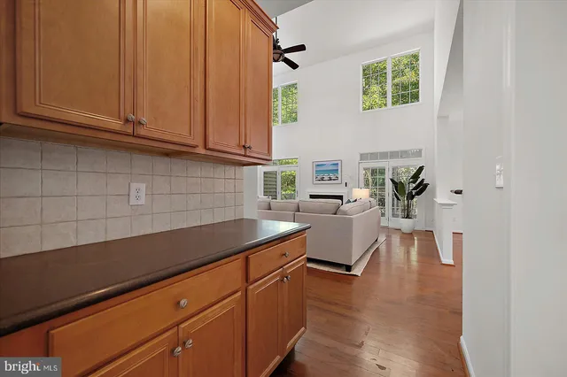 a dining room with wooden floor a chandelier a wooden table and chairs