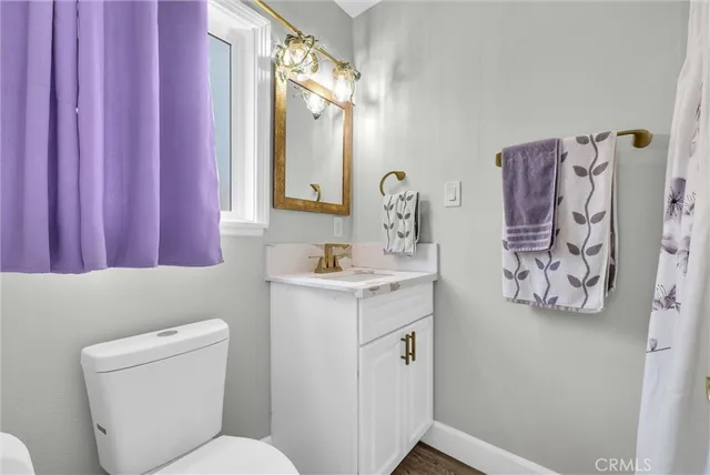 a bathroom with a toilet sink vanity and mirror
