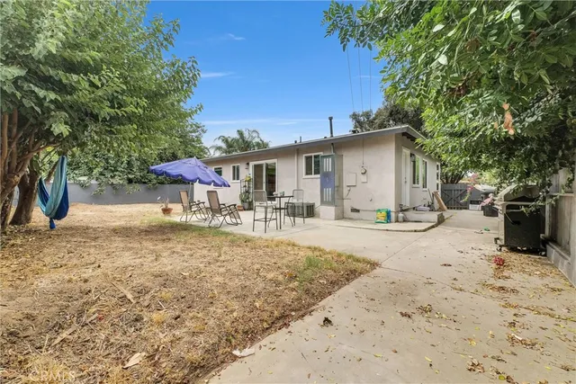 a view of a house with backyard and sitting area
