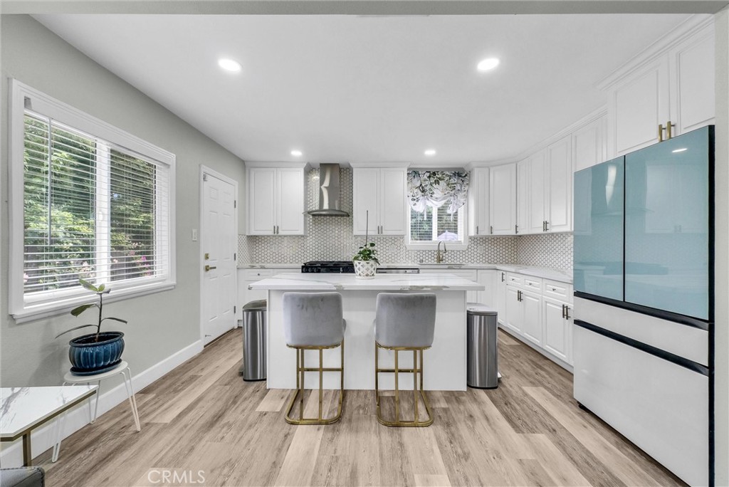 3625 Ross Street Riverside, CA 92503 - Photo 9 of 29 a kitchen with stainless steel appliances a table chairs refrigerator microwave and cabinets