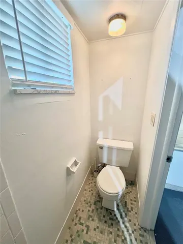 a white toilet sitting next to a window