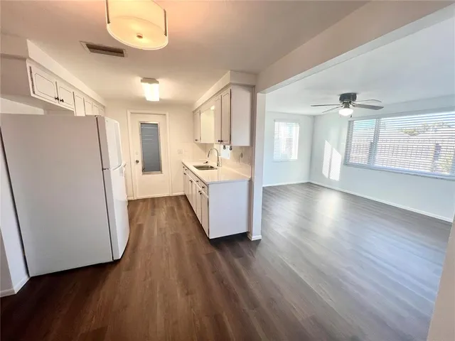 a living room with hard wood floors and white walls