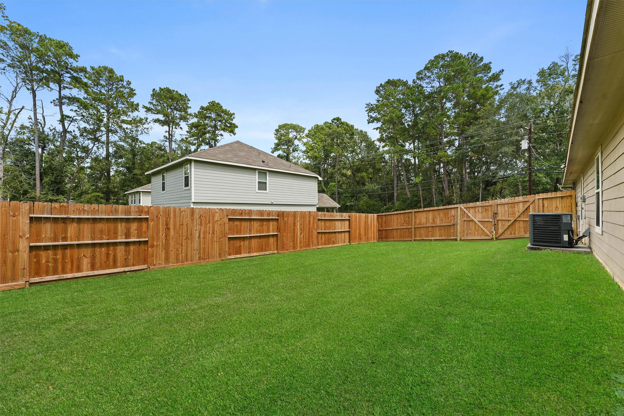 15177 Coaltown Road Willis, TX 77378 - Photo 24 of 25 a backyard of a house with wooden fence and large trees