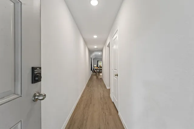 a view of a hallway with wooden floor and staircase