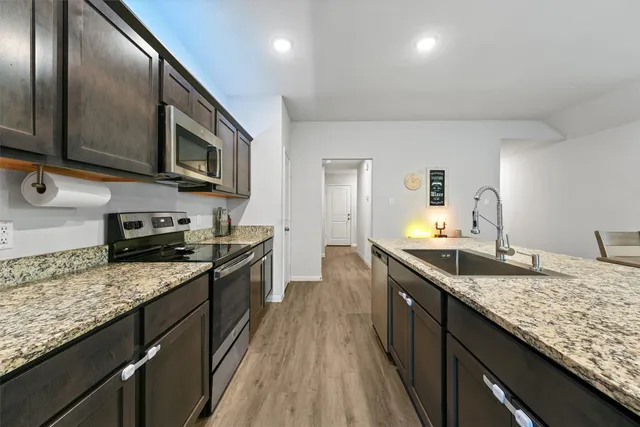 a kitchen with granite countertop stainless steel appliances and sink