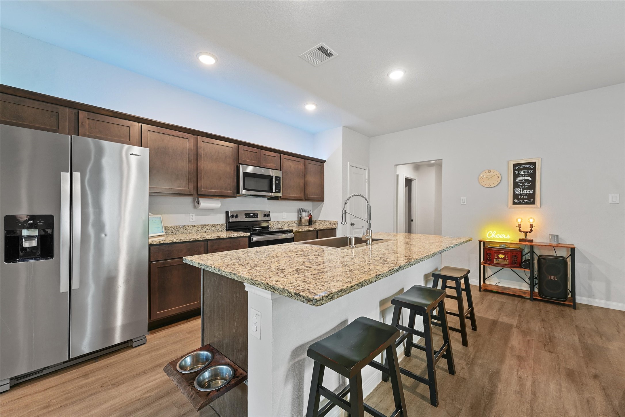 15177 Coaltown Road Willis, TX 77378 - Photo 6 of 25 a kitchen with stainless steel appliances granite countertop a table chairs refrigerator and sink