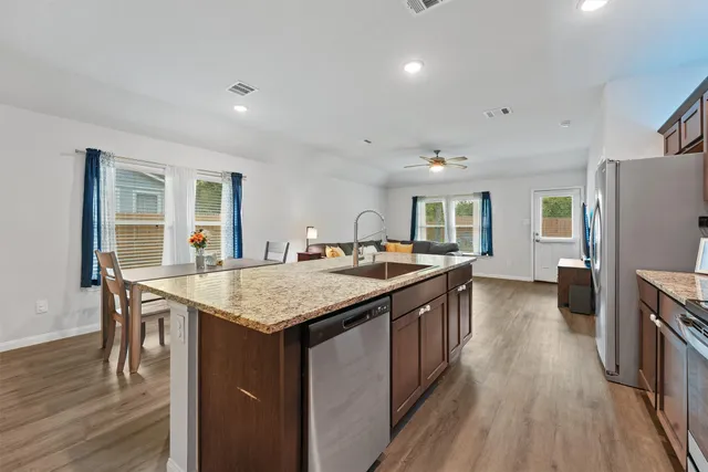 a kitchen with granite countertop a stove and a wooden floors