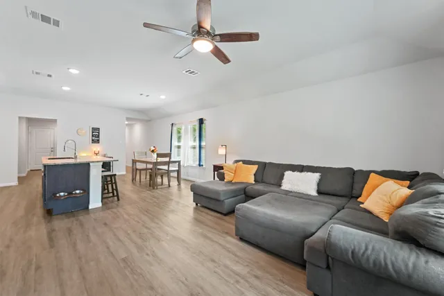 a living room with furniture and wooden floor