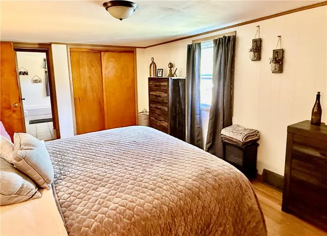 a bedroom with a bed and wooden floor