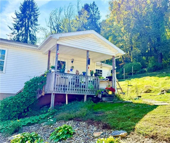 a view of a house with a backyard and a wooden deck