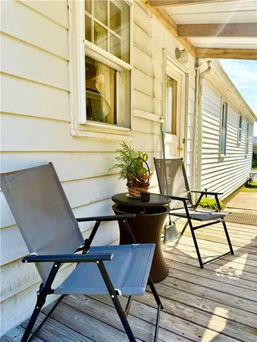 a view of a balcony with chairs and wooden floor