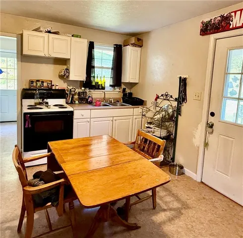 a kitchen with a table chairs sink and cabinets